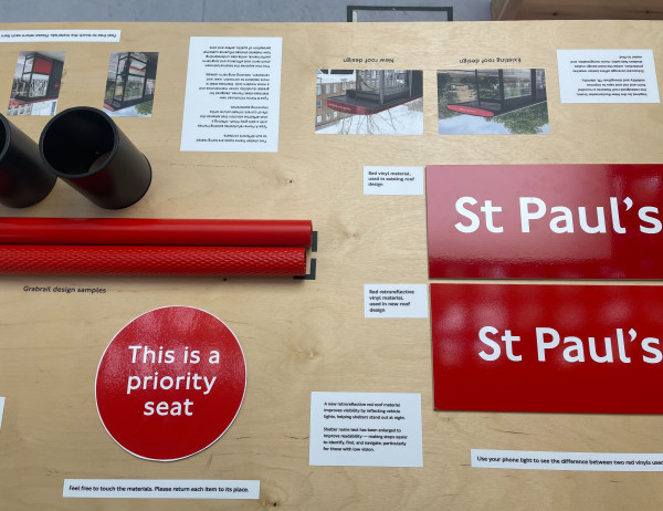 A wooden exhibition table with materials and signage from the new TfL bus shelter design